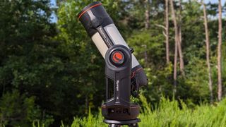 a black and white telescope in a field